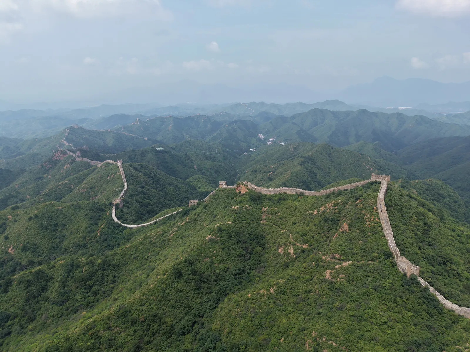 La Grande Muraille serpentant sur les crêtes vertes, vue de notre drone