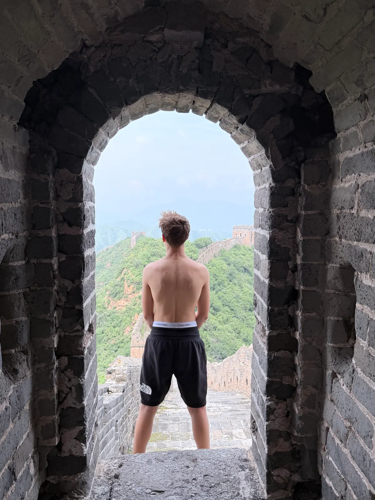 Alexis encadré dans la fenêtre d'une tour de Jinshanling