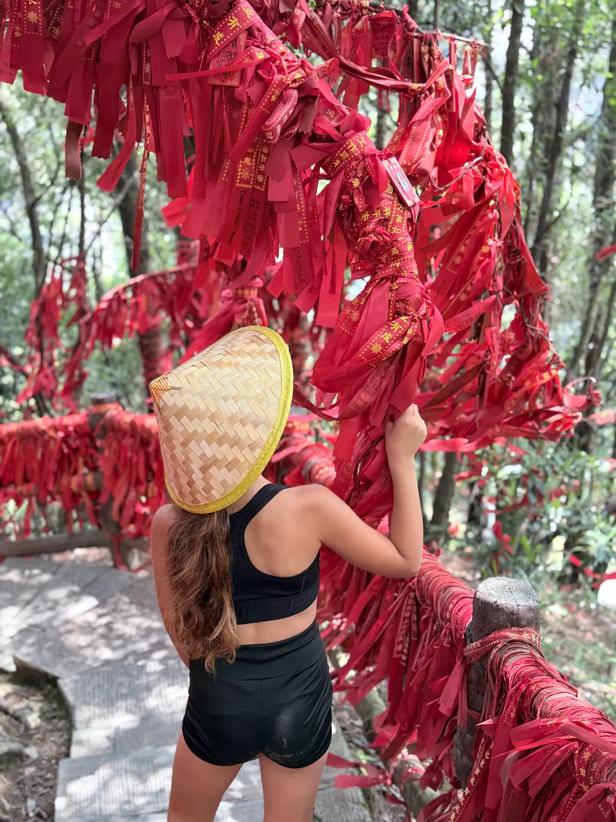 Emma devant le mur de rubans rouges porte-bonheur près du Premier Pont