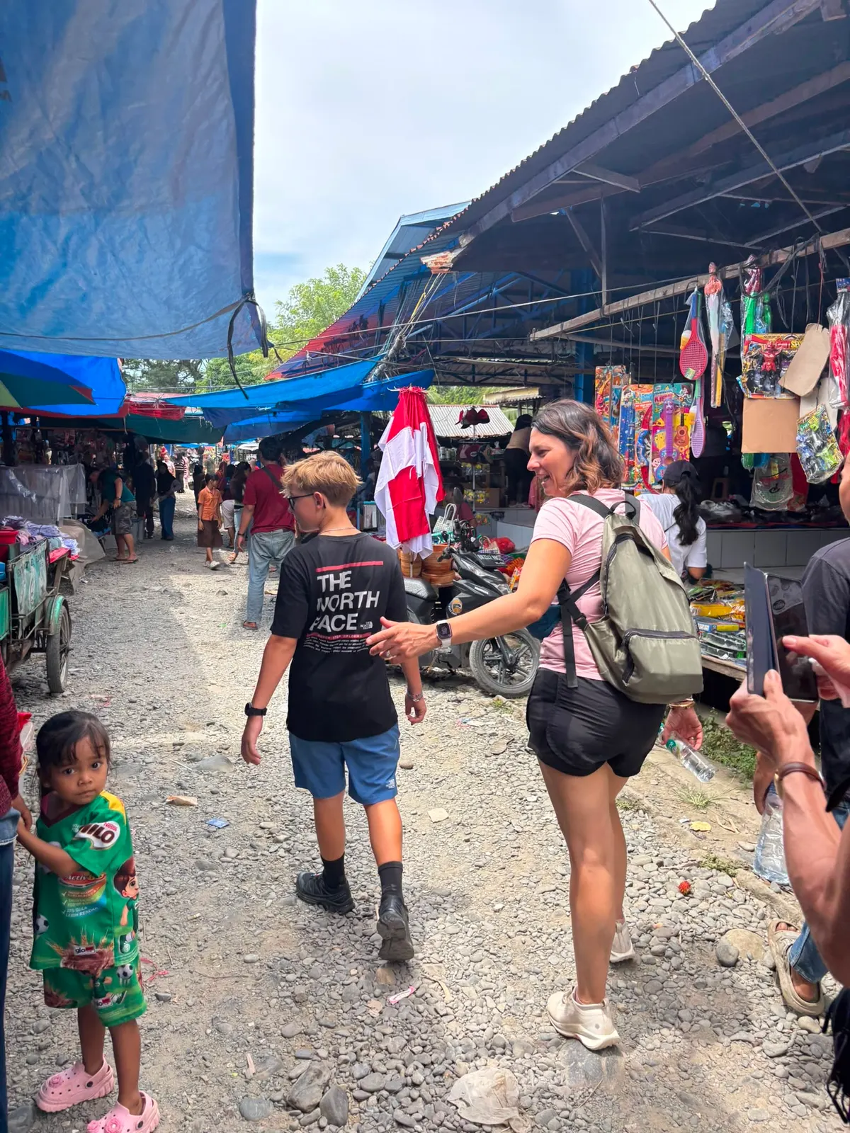 Dans les allées du marché du village, entre étals, drapeaux indonésiens et tuk-tuks