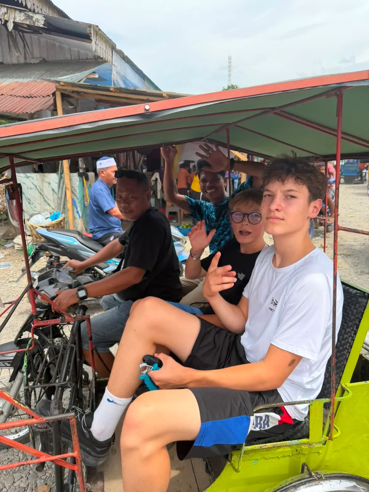 En becak — la moto-side-car locale — à travers le marché avec les copains