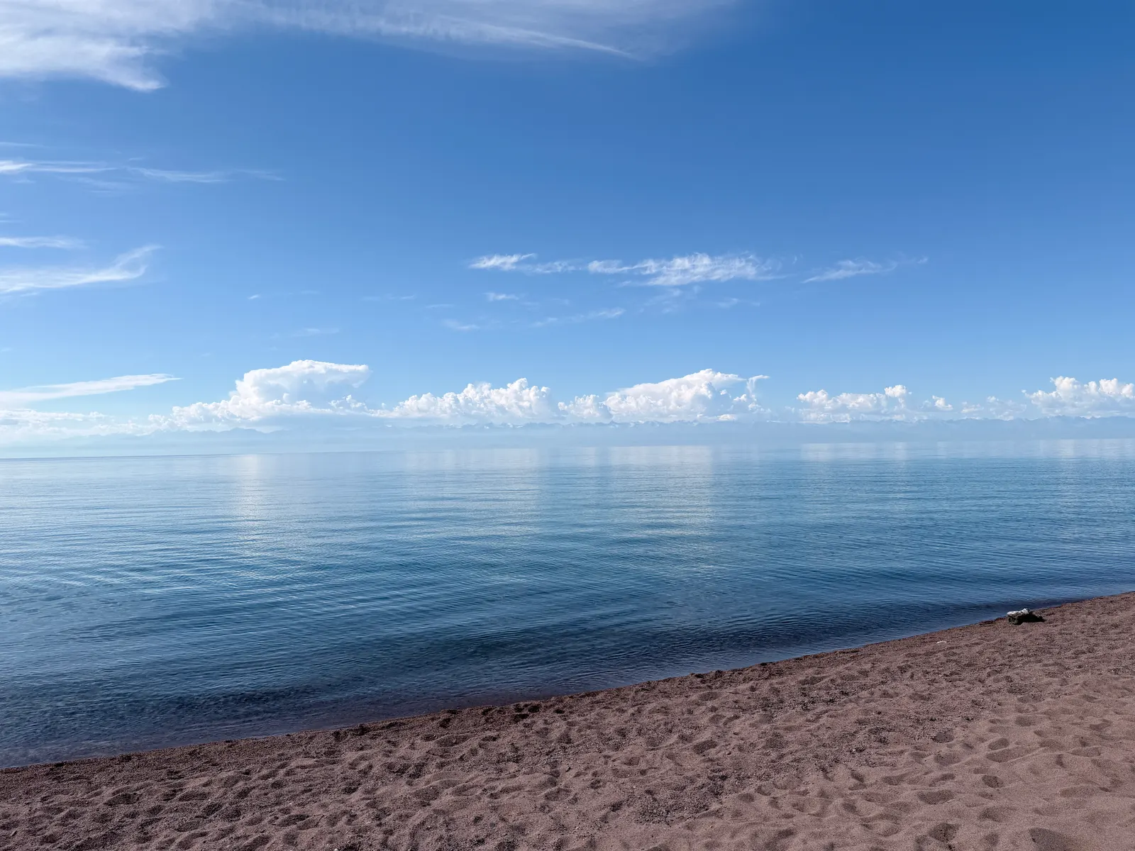 Une plage déserte de l'Issyk-Koul, le lac filant jusqu'aux montagnes enneigées