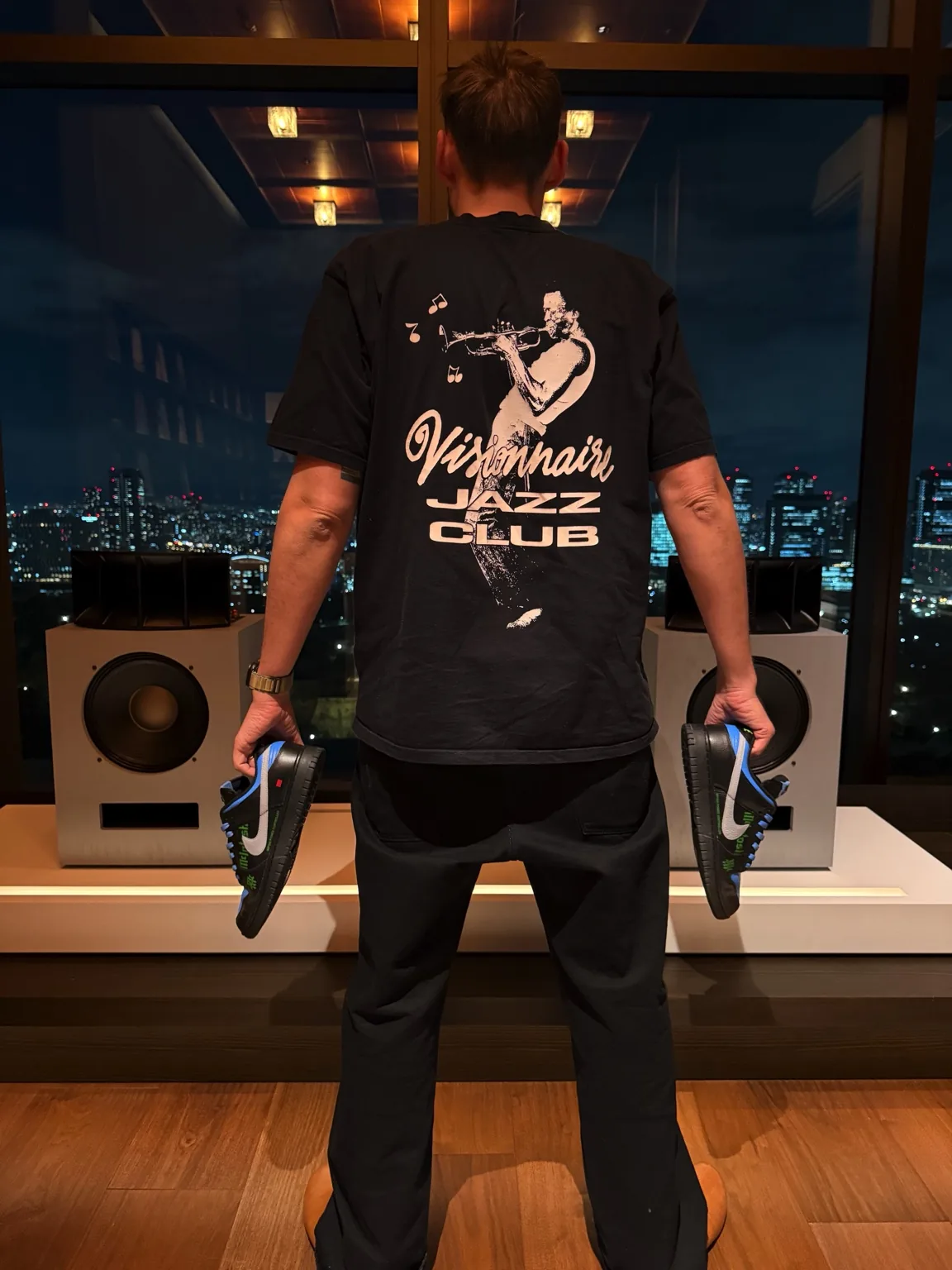 Hugo Lahutte between two Klipsch Ojas speakers, holding a custom Nike McIntosh, in Osaka